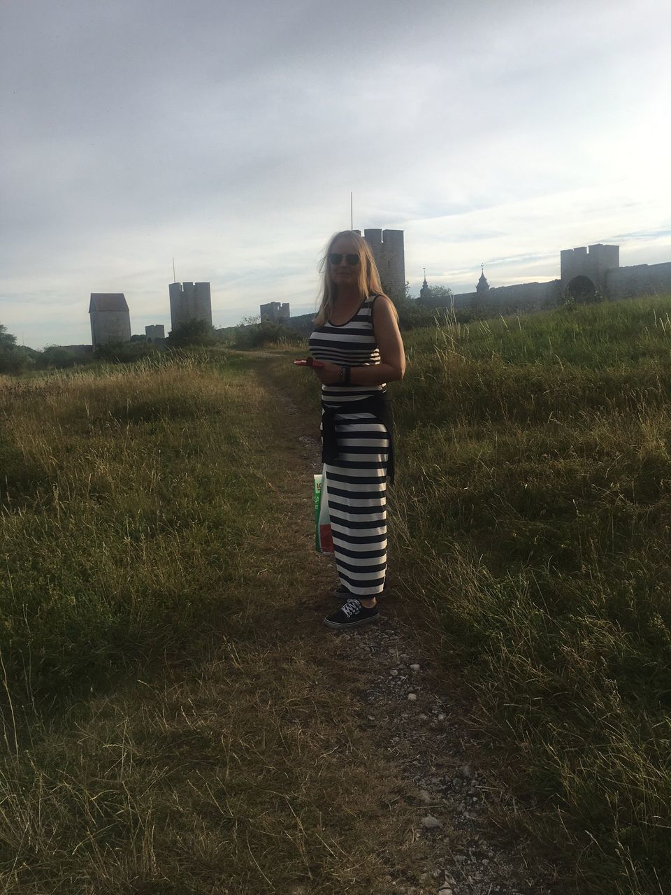 full length, lifestyles, casual clothing, leisure activity, grass, sky, field, day, outdoors, cloud - sky, landscape, enjoyment, grassy, nature, fun