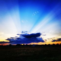 Scenic view of silhouette field against sky at sunset