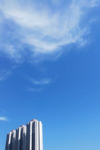 Low angle view of skyscrapers against blue sky