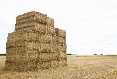 Hay bales on field against sky