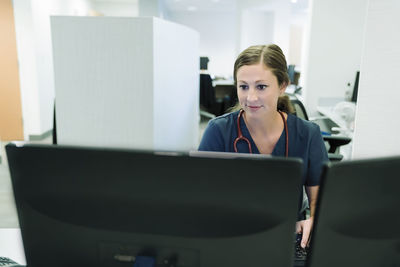Confident female doctor using desktop computer in hospital
