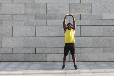 Full length of man standing against wall