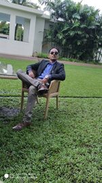 Young man sitting on seat in park