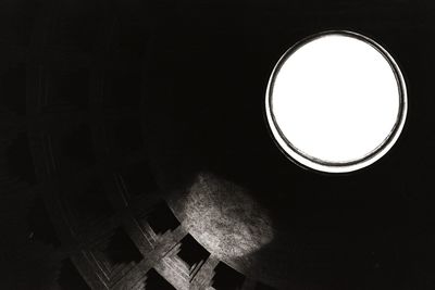 Low angle view of illuminated window against black background