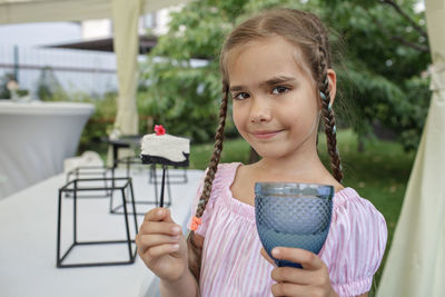 Portrait of smiling young woman drinking outdoors