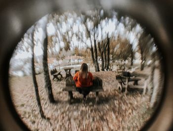 Rear view of woman sitting on glass