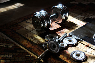 High angle view of dumbbell and barbell on carpet