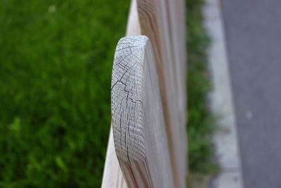 Close-up of wooden fence by grassy field