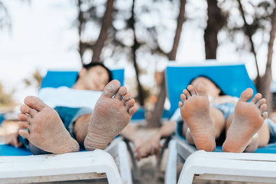 Low section of people sitting on chair