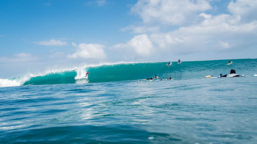 People in sea against sky