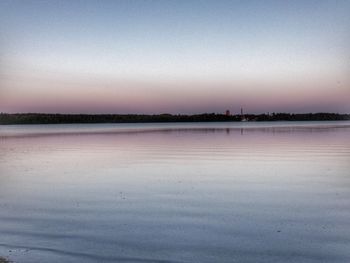 Scenic view of lake against clear sky during sunset