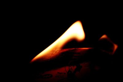 Close-up of lit candles in darkroom