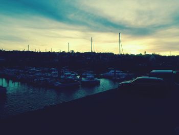 Boats moored on shore against sky during sunset