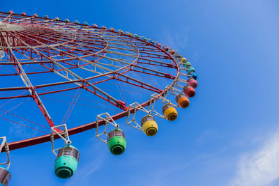 Low angle view of ferris wheel against blue sky