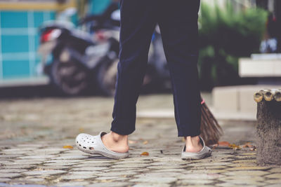 Low section of man standing on footpath