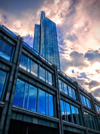 Low angle view of modern building against cloudy sky