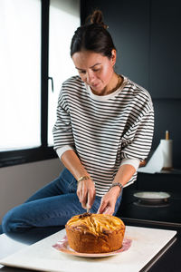 Side view of young woman holding food at home