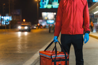 Rear view of man standing on street at night