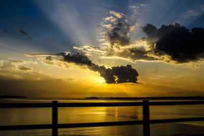 Scenic view of sea against dramatic sky during sunset