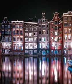 Reflection of illuminated buildings in city at night, amsterdam 