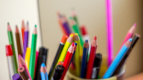 Close-up of colored pencils against wall