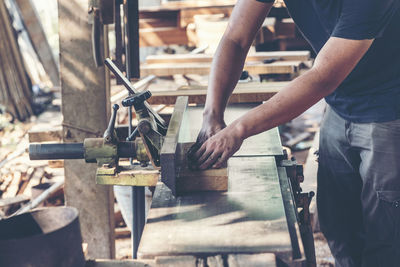 Carpenter cutting wood in workshop