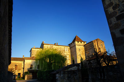 Low angle view of old building against clear blue sky