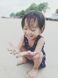 High angle view of girl playing with sand at beach