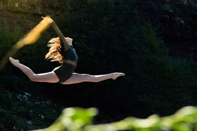 Woman dancing against rock