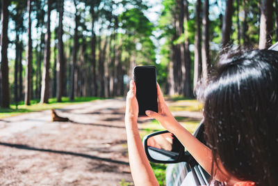Man using mobile phone in forest