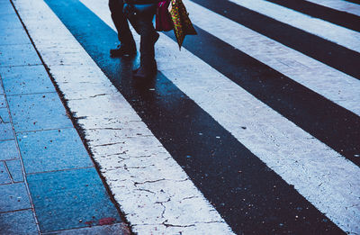 Low section of woman walking on zebra crossing