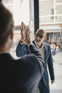 Senior and mid-adult businessman high fiving