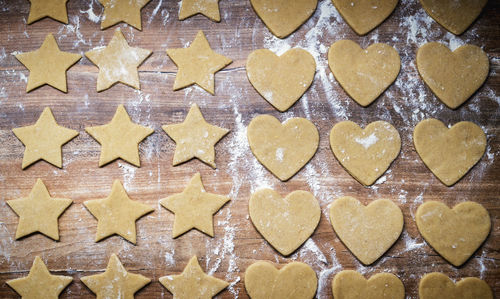 Christmas baking gingerbread. cookie dough in heart and star shape on kitchen counter. top view.