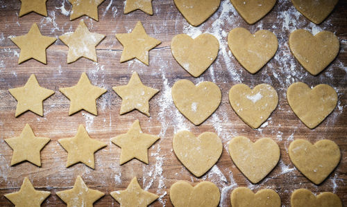 Christmas baking gingerbread. cookie dough in heart and star shape on kitchen counter. top view.