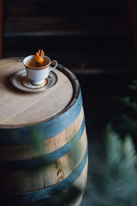 Hot toddy cocktail in teacup on bourbon whiskey barrel