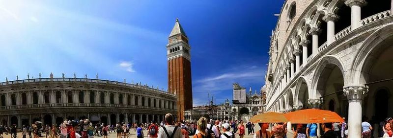 Tourists in front of building against sky