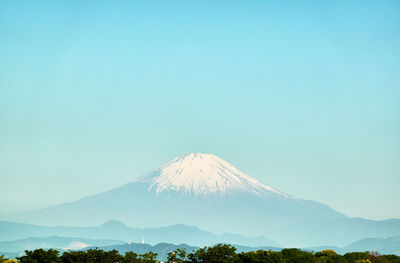 Scenic view of volcanic mountain against blue sky