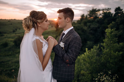 Rear view of couple kissing at sunset