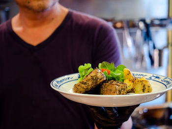 Midsection of man having food in restaurant