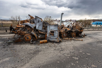 Burnt military vehicles of russian soldiers on the bridge across the river. rusty cars.