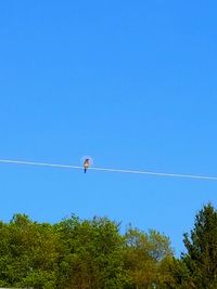 Low angle view of vapor trail against clear blue sky