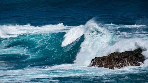 Waves breaking on rocks in sea