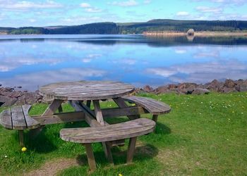 Wooden table with benches on the shore of kielder water