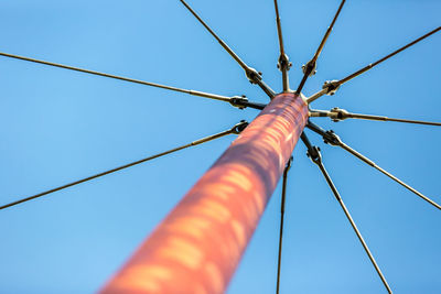 Low angle view of cables against clear blue sky