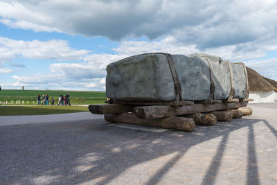 Group of people on road against cloudy sky