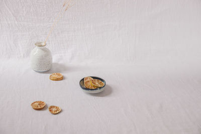 Dried lemon slices on a white delicate background showing the spring and summer aesthetics