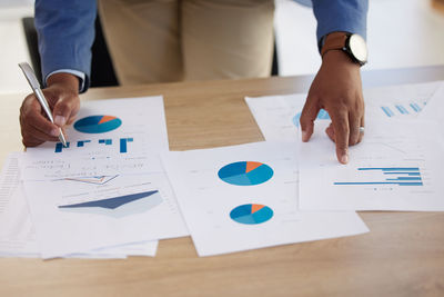 Midsection of business people working on table