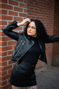 Young woman standing against wall