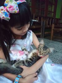 Full length of cute girl with cat