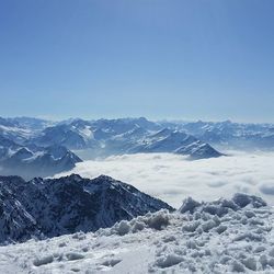 Scenic view of snowcapped mountains against clear blue sky